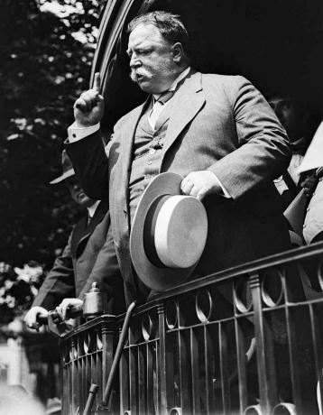Fekete-fehér fotó William Howard Taft elnökről, aki egy kampánybeszédet tart egy vonatplatformról.