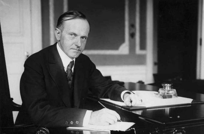 Fénykép Calvin Coolidge-ről a Fehér Ház íróasztalánál.