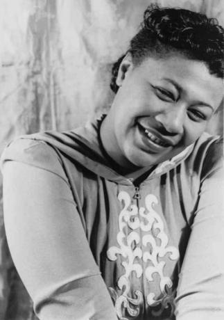 Fekete-fehér fénykép Ella Fitzgerald mosolyogva.