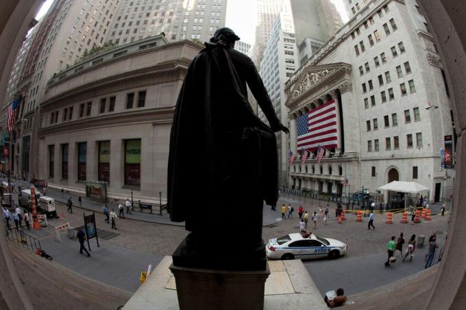 A New York-i tőzsde homlokzatát egy hatalmas amerikai zászló mögött, amely az oszlopsorot borítja, a George Street-i szobor figyeli a Wall Street-en.