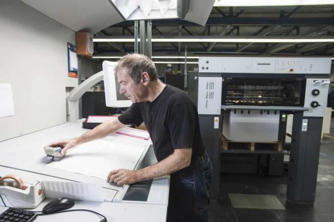 Munkavállaló digitális nyomtató berendezések előkészítése a nyomdában