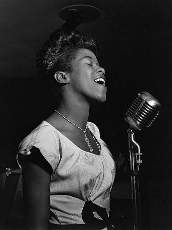 Sarah Vaughan mikrofonba énekel, fekete-fehér fénykép.