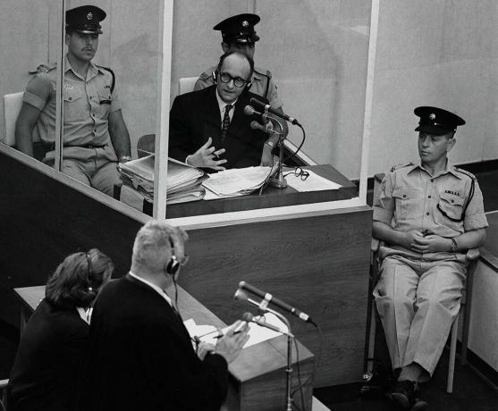 A náci háborús bűnöző, Adolph Eichmann egy védőüveg-kabinban áll, amelyet az izraeli rendőrség a 1961. június 22-i Jeruzsálemben zajló tárgyalása során tartott.